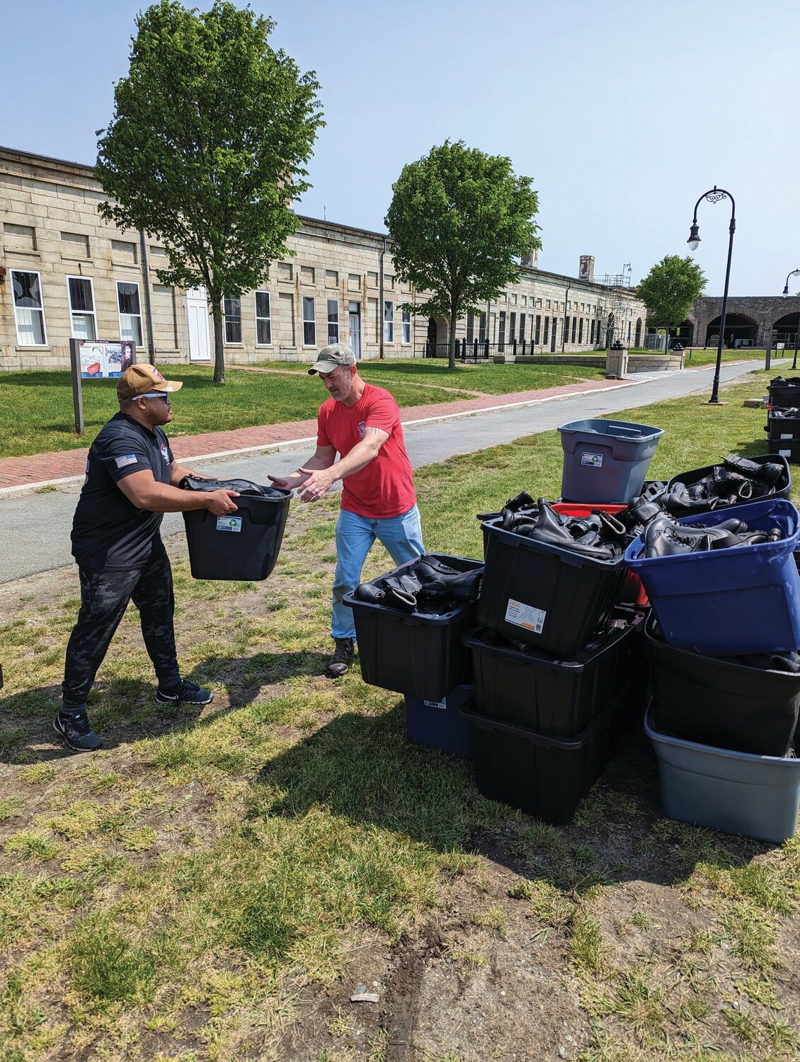 SET UP BEGINS: Dispersing the boots, Santos Perez (left) and George Luttge (right), spent Monday working to set up for the Boots on the Ground event.
